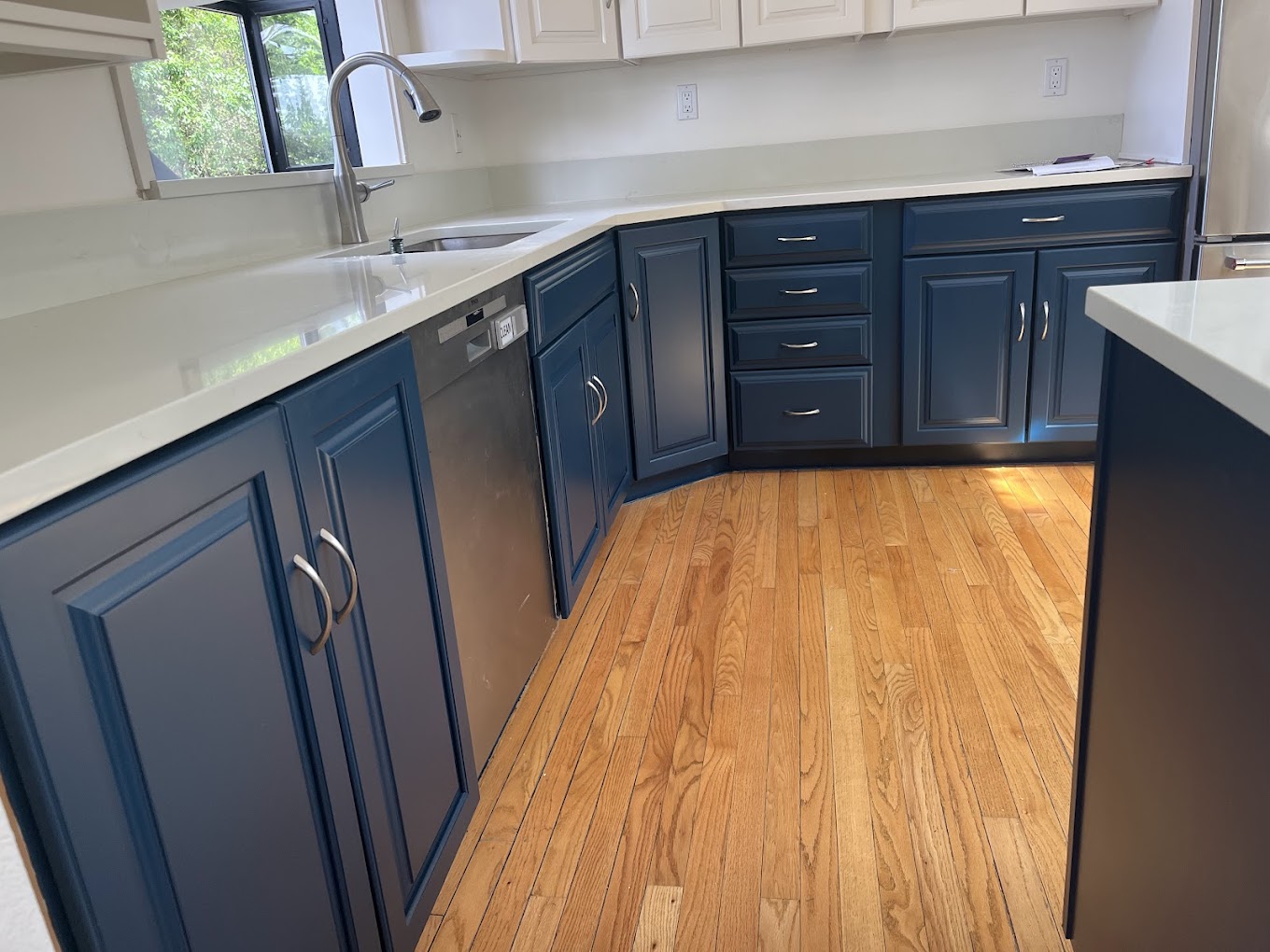 Kitchen cabinet painting Redmond WA — navy blue refinished cabinets with quartz counters in remodel