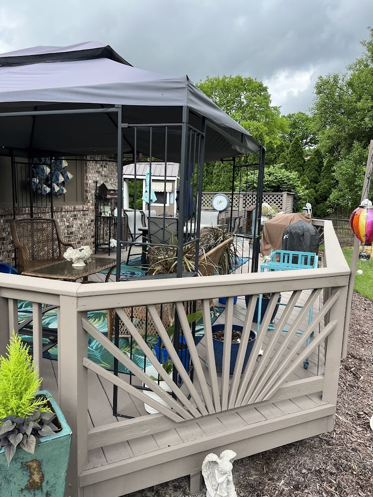 Deck painting Redmond WA — tan deck with custom sunburst railing pattern and gazebo