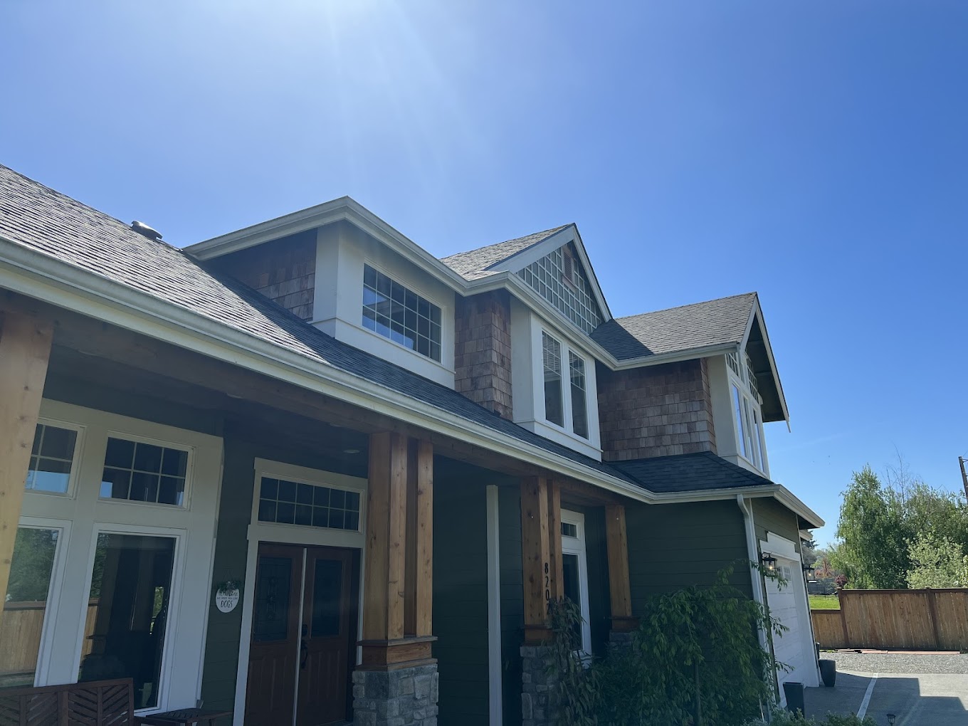 Exterior house painting Redmond WA — premium craftsman home with cedar shake gables, deep green siding, stone columns and white trim