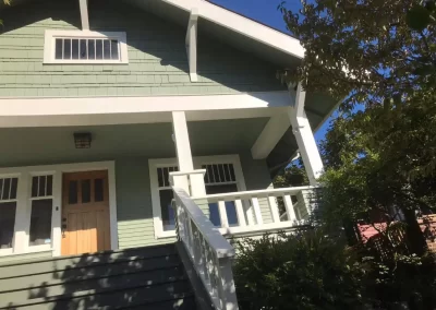 Exterior home painting contractor Redmond Washington — sage green craftsman bungalow with white porch