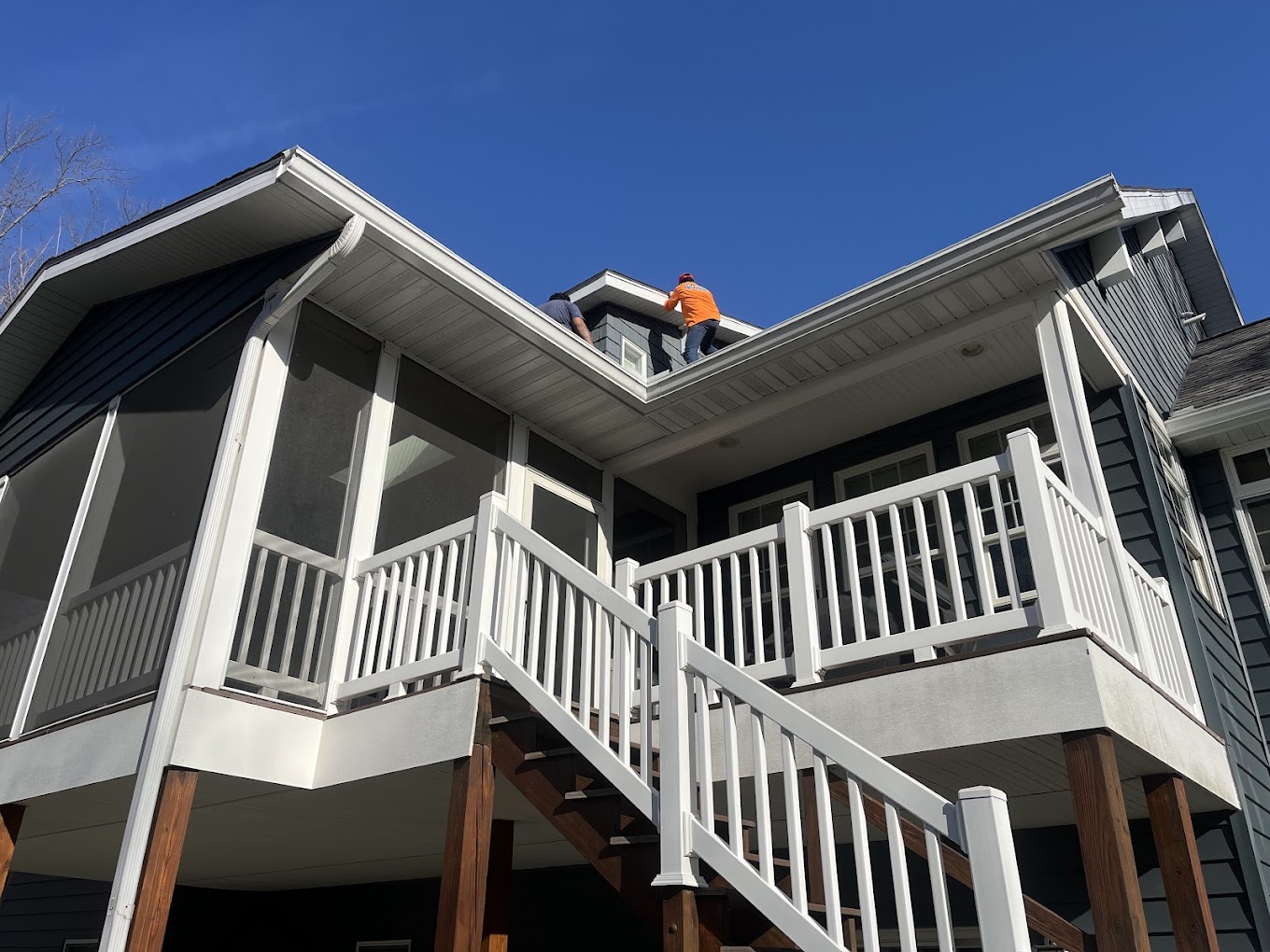 Exterior house painter Redmond WA — Redmond Pro Painting crew on craftsman porch roof prepping trim