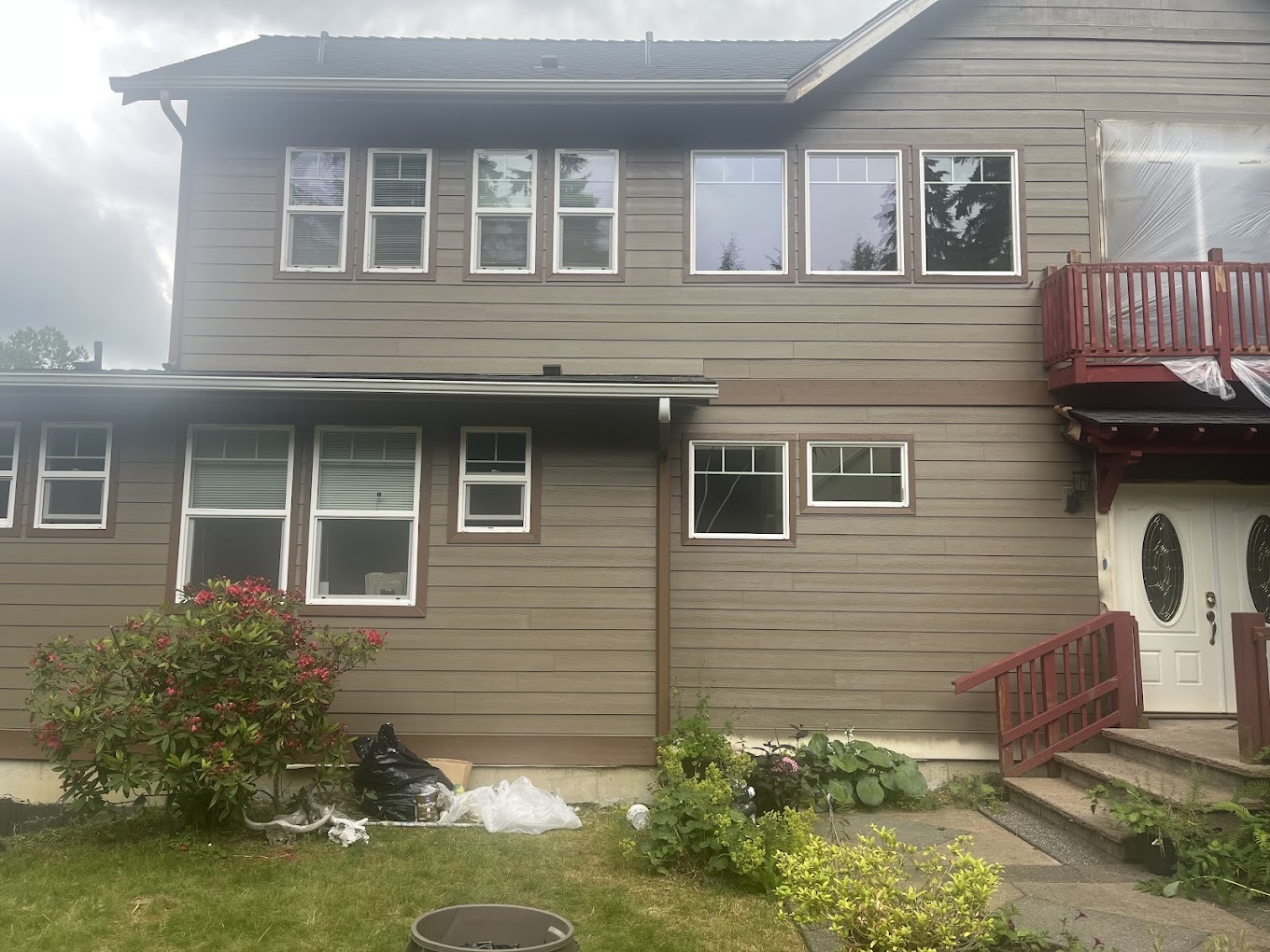 Exterior house painting Redmond WA — two-story home with freshly painted warm taupe lap siding and white window trim