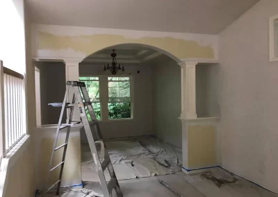 Interior painting prep in Redmond WA — archway with primer coat and floor protection in dining room
