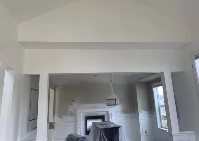 Interior painting Redmond WA — vaulted ceiling living room with fresh white walls and fireplace mantle
