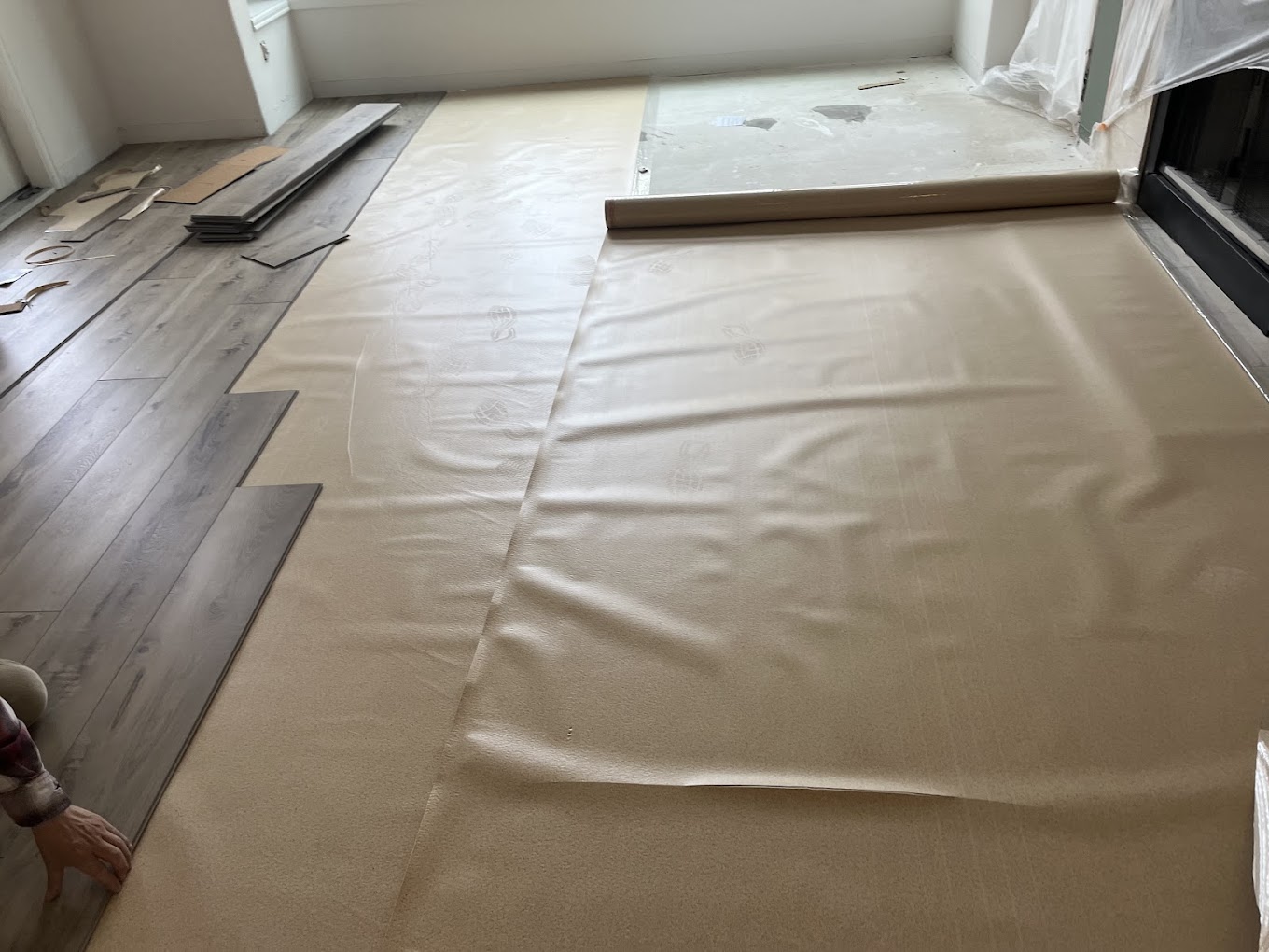 Laminate flooring installation Redmond WA — gray-wash laminate planks being installed over underlayment