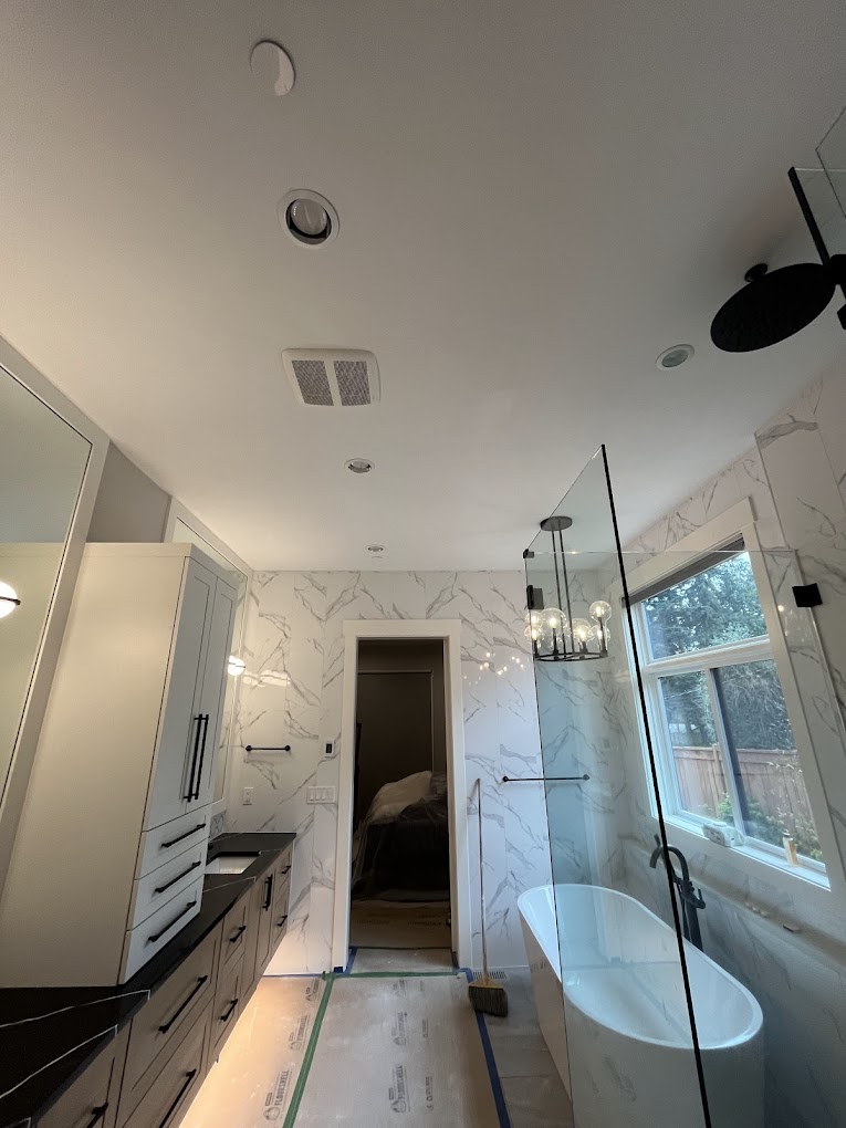 Bathroom remodel Redmond WA — finished luxury master bath with marble walls, freestanding tub and rainfall shower