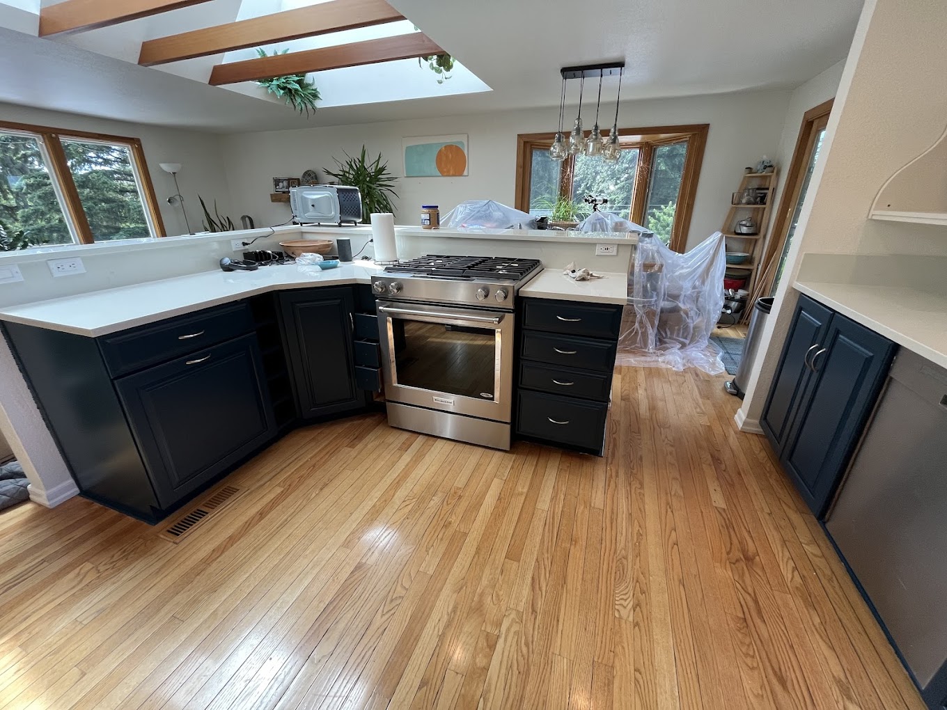 Kitchen remodel Redmond WA — refinished navy cabinets in a skylit kitchen with hardwood floors and quartz counters