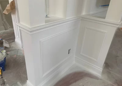 Trim carpentry and painting Redmond WA — close-up of crisp white wainscoting panels and baseboards